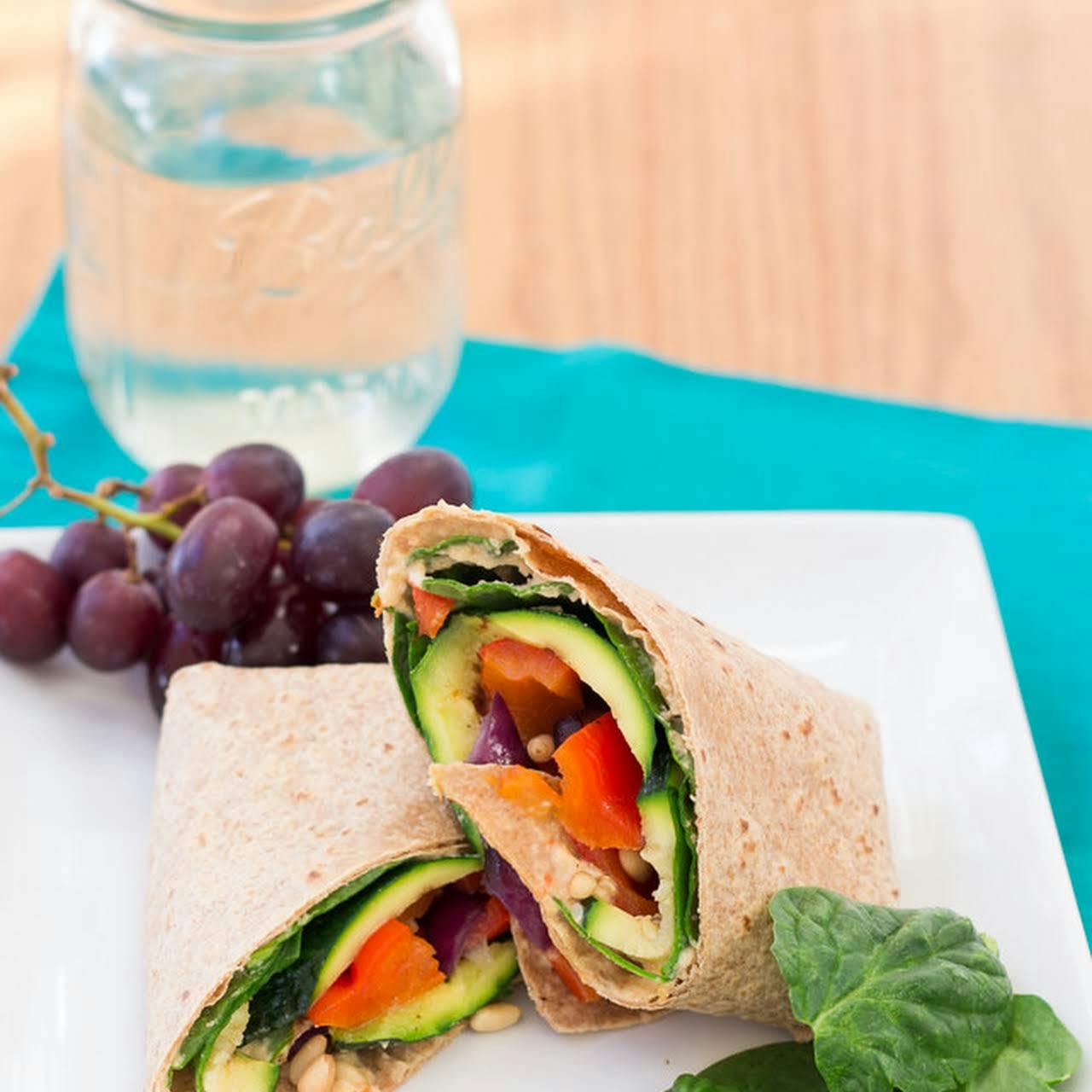  A carrot, hummus, and arugula wrap with grapes and walnuts
