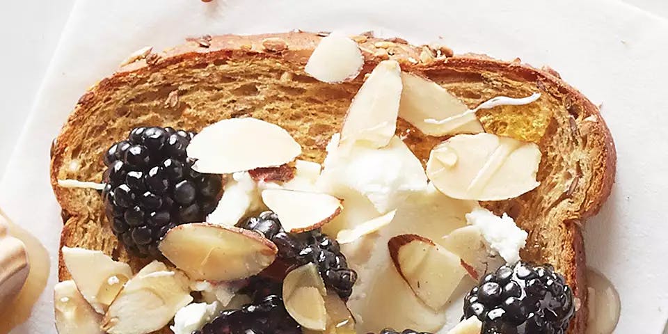 One slice of toast topped with goat cheese, blackberries
